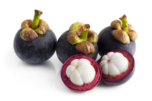 Mangosteen fruit and cross section showing the thick purple skin and white flesh of the queen of fruits.