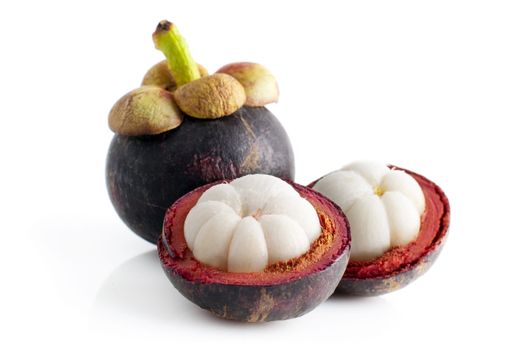 Mangosteen fruit and cross section showing the thick purple skin and white flesh of the queen of fruits.