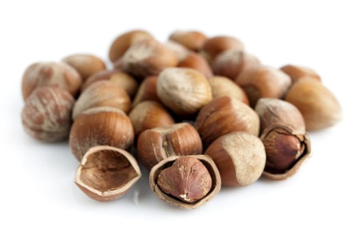 Closeup of whole and cracked hazelnuts. Isolated on white background.