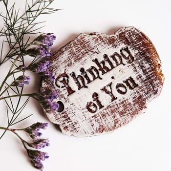 The words Thinking Of You engraved on a small wooden plaque