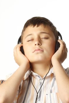 Boy with headphones listening to music over white 