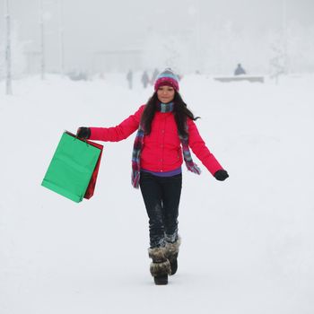 winter girl with gift bags on snow background