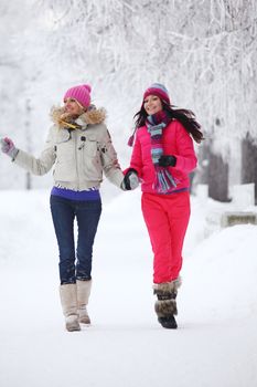 two winter women run by snow frosted alley