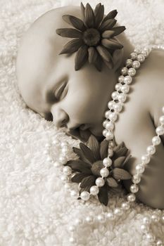 Beautiful newborn baby girl with flowers and pearls