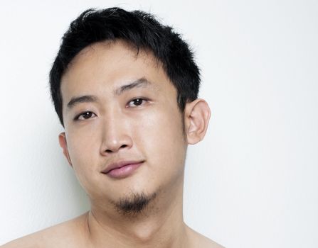 Pan Asian male portrait on plain background