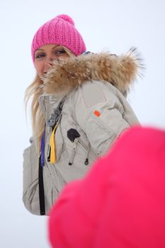 winter woman play snowballs on snow background