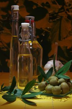 Olive oil with olive branch and fresh olives and garlic