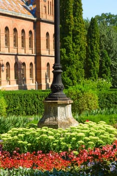 Bed, flowers, building, green, brick, lawn, bed, column, iron, old, red, white, fence, leaves, summer, trees, windows, roof, floral, flowers