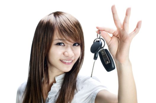 Young girl holding car key on white background