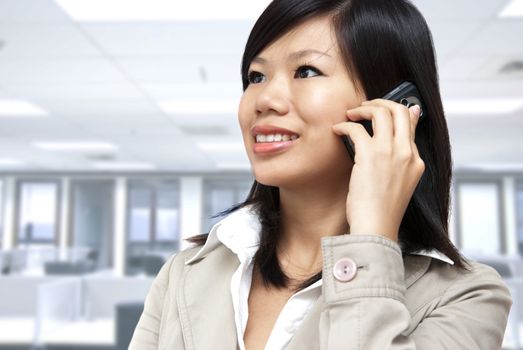 Asian Businesswoman on the phone inside of office.
