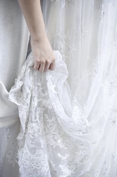 Bridemaid holding bride's wedding dress