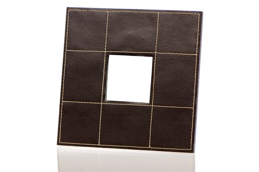 Leather picture frame on white reflective background.