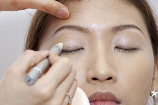 Woman applying cosmetic with applicator. Make-up treatment.