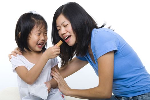 Little girl feeding her mum cone ice-cream.