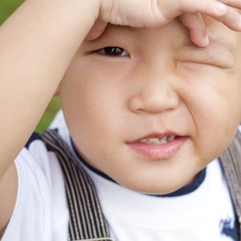 Little Asian boy is confusing, close up face.