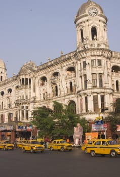 Yellow taxis crossing a busy road junction in Calcutta West Bengal India.