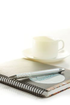 Pen on a white paper with cup of coffee