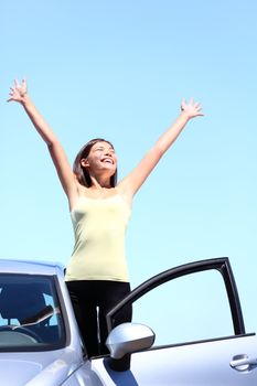 happy woman in car enjoying her freedom on vacation summer road trip. Beautiful young multiracial model