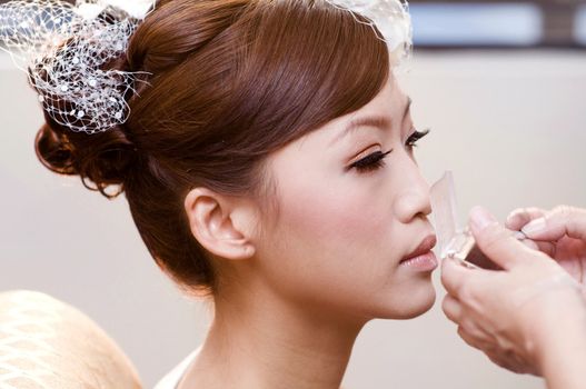 Bridal applying cosmetic with applicator. Make-up treatment.