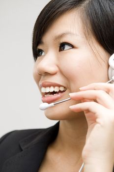 Friendly Customer Representative with headset smiling during a telephone conversation.