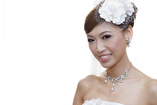 Beautiful Asian bride smiling, on white background.