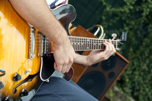 hands of a musician who plays electric guitar