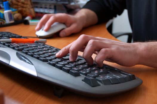 male hand typing on black keyboard