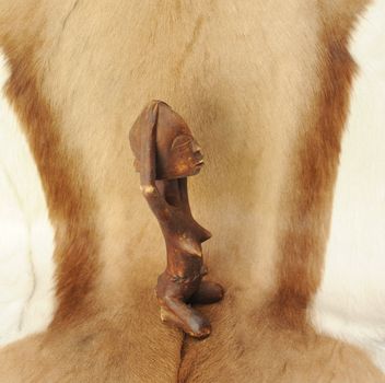 Lovely Naked African Wooden Figure on 
Natural Animal Fur.