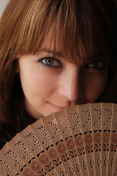 Beautiful brown haired girl with opened fan