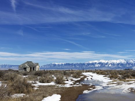 Scenic landscape in rural snowy Colorado of abandoned house.