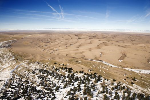 Aerial landscape of snowy plains and dunes in Great Sand Dunes National Park, Colorado.