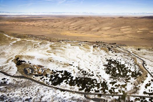 Aerial landscape of snowy plains and dunes in Great Sand Dunes National Park, Colorado.