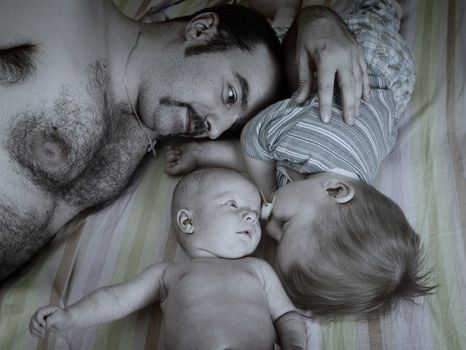 father and children repose .Newborn baby girl and small boy.monochrome