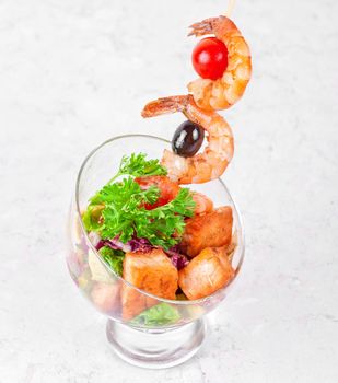 Fried kebab of shrimps with vegetables, greens and salmon fish