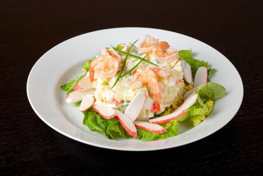 Salad of shrimps, crab meat, cucumbers, apples, potatoes, lettuce, maize, eggs and mayonnaise