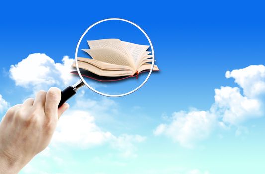 Magnifying glass over of book on the sky