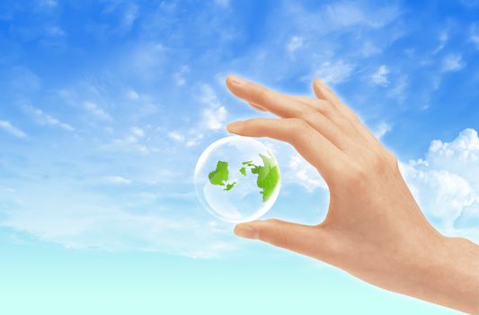 Eco concept : Hand hold globe  against   and the blue sky