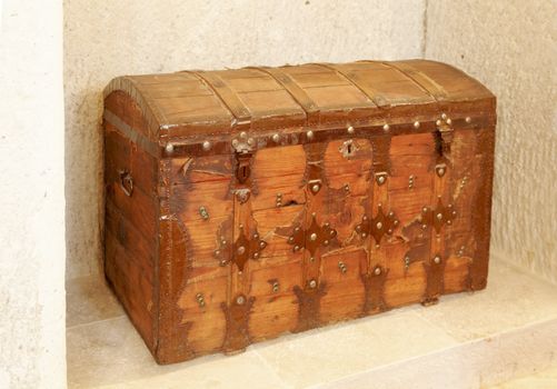 wooden chest, iron clasps and reinforcements, traveling treasure chest, horizontal with copy space set in a limestone alcove