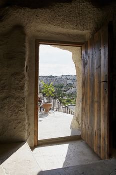Open doorway of Koza Cave with a view of Goreme hills and natural chimney caves, Cappodocia, Turkey. Portrait copy space