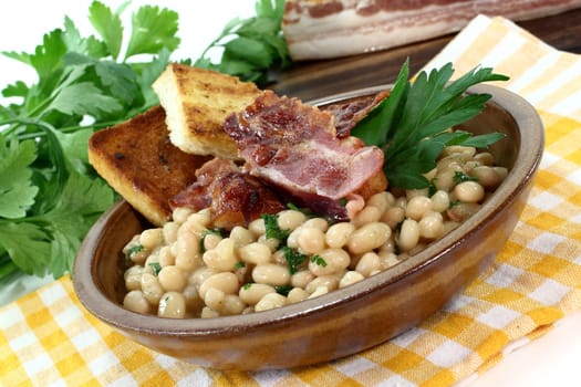 a bowl of white beans and fried bacon