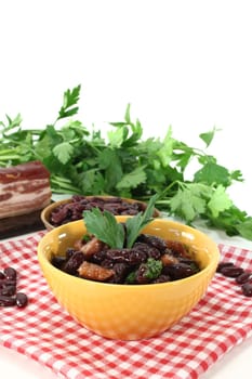 Kidney beans with fried bacon and fresh parsley