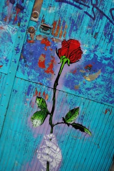 A graffiti piece depicting a hand holding a rose.