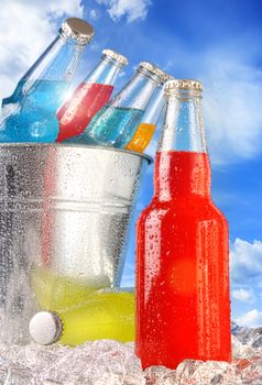 Close-up view of bottles with ice against blue sky