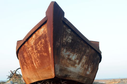 Old iron boat parked at riverside