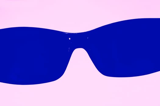 Glasses of saturated blue on the pink gradient background. The concept for summer