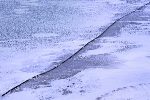 A long crack on the thin snowy ice water reservoir