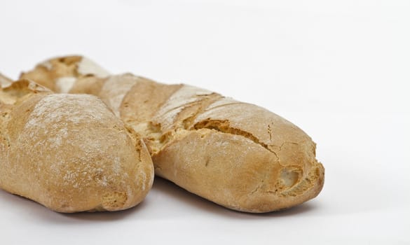 part of two baguettes on light background