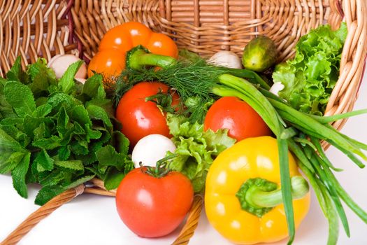 Basket with vegetables isolated on white background.