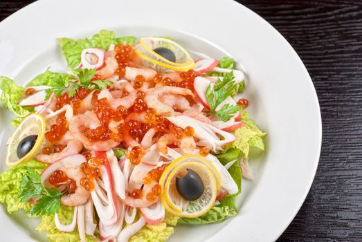 Salad with shrimps, caviar, calamaries, lettuce, lemon and olive