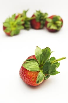 single isolated strawberry with other strawberries in the background.